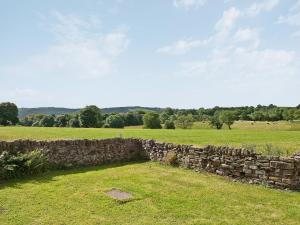 a stone wall in the middle of a field at The Cowshed in Froghall