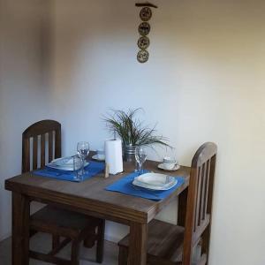 una mesa de madera con platos y copas de vino. en Mono ambiente Loria en Luján de Cuyo