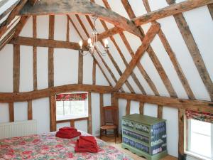 a bedroom with a bed in a room with wooden beams at Bell Corner Cottage in Cratfield