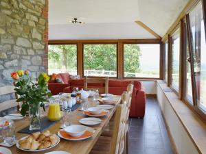 a dining room with a long table with plates of food at Gorsddu in Llanwrthwl