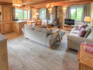 a living room with two couches and a television at Hadrians Garden Villa in Bardon Mill