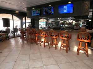 a bar with wooden chairs and a counter in a restaurant at Naples Dream at WTC with Heated Pool SPA Sauna 7 bicycles and 3 mls to beach in Naples