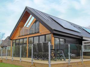 a house with a solar roof with a table and chairs at Caracol - Cccf in Wroxham