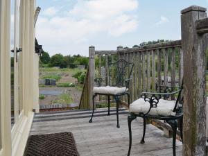 two chairs on the porch of a house at Hurdlemakers Loft in Upper Brailes