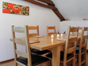 a wooden dining room table with chairs and candles at Dairy Cottage in Barnstaple