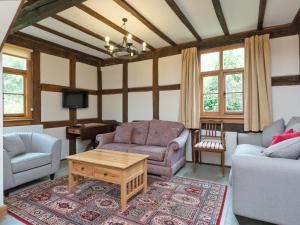 a living room with a couch and a table at Brook House in Mathon