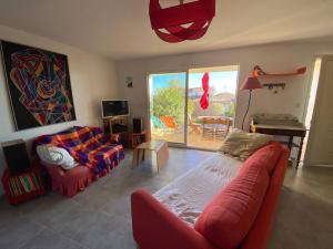 a living room with two red couches and a table at Villa Leucate, 4 pièces, 7 personnes - FR-1-81-578 in Leucate