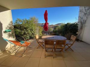 a patio with a table and chairs and an umbrella at Villa Leucate, 4 pièces, 7 personnes - FR-1-81-578 in Leucate