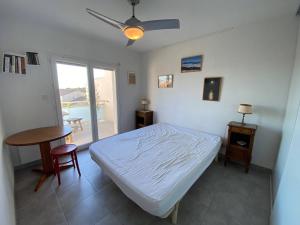 a bedroom with a bed and a table and a window at Villa Leucate, 4 pièces, 7 personnes - FR-1-81-578 in Leucate