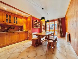 a kitchen with a wooden table and some chairs at Appartement spacieux 8 pers, village, parking, fibre - FR-1-505-183 in Notre-Dame-de-Bellecombe