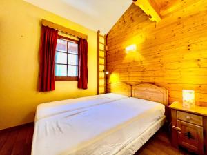a bedroom with a bed in a wooden room at Appartement spacieux 8 pers, village, parking, fibre - FR-1-505-183 in Notre-Dame-de-Bellecombe +14 photos