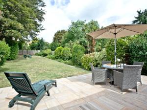 a patio with a table and chairs and an umbrella at Oldway Apartment in Paignton