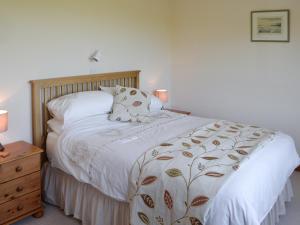 1 cama con edredón blanco y 2 almohadas en Glenbank, en Maxwelton