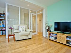 a living room with a television and a chair at Oldway Apartment in Paignton
