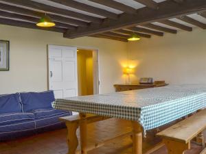 uma sala de estar com uma mesa e um sofá azul em Cronkhill Farmhouse em Wroxeter