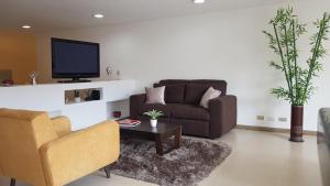 een woonkamer met een bank en een tv bij Apartamento Parque Virrey in Bogota