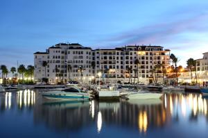 un gran edificio con barcos en un puerto deportivo por la noche en Duquesa Harbour Club Aparthotel, en Manilva