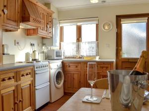 a kitchen with a white stove top oven next to a dishwasher at Draigs Cottage in Abergavenny