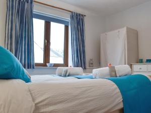 a bedroom with a large bed with blue curtains at Draigs Cottage in Abergavenny