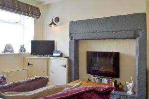 a living room with a fireplace and a tv at Cosy Nook in Cromford
