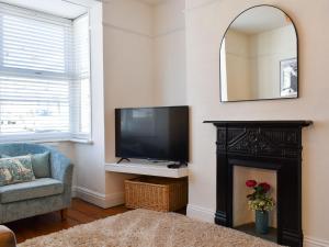 a living room with a television and a fireplace at Turnstone in Bideford