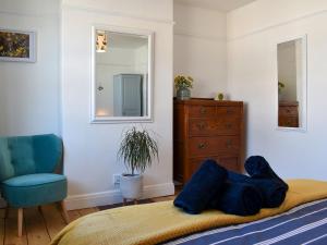 una camera con letto, sedia e specchio di Turnstone a Bideford