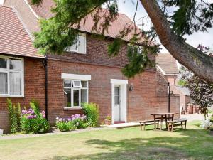 een stenen huis met een picknicktafel in de tuin bij Eventide in Biggleswade