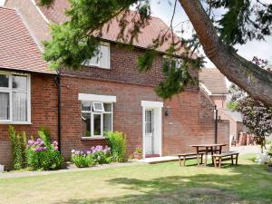 a brick house with a picnic table in the yard at Eventide in Biggleswade