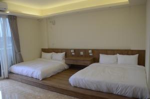 duas camas sentadas uma ao lado da outra num quarto em Rebecca Hostel em Chaozhou