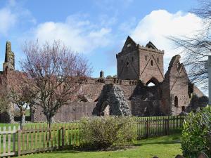 an old castle with a fence in front of it at Burnbank in Kirkgunzeon