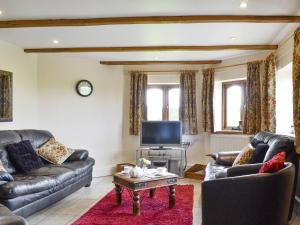a living room with two couches and a tv at White Hill Farm Cottage in Dingestow
