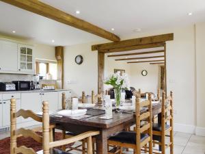 a kitchen and dining room with a wooden table and chairs at White Hill Farm Cottage in Dingestow