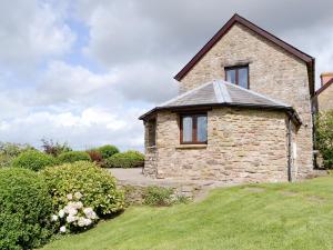 uma casa de pedra com uma janela ao lado em White Hill Farm Cottage em Dingestow