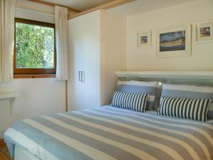 a bedroom with a bed with two pillows and a window at Tigh An Uillt in Strachur