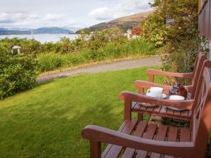 a wooden bench with a tray of tea cups on it at Tigh An Uillt in Strachur