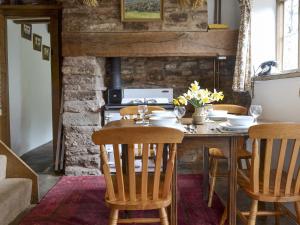 een eetkamer met een houten tafel en stoelen bij Titchbourne Cottage in Clee Saint Margaret