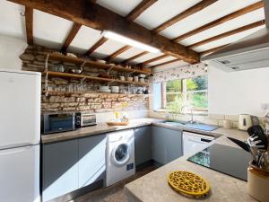 een keuken met een wasmachine en droger. bij Titchbourne Cottage in Clee Saint Margaret
