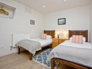 two beds in a room with white walls at Below Decks in Turnchapel