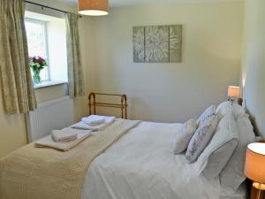 een slaapkamer met een bed met witte lakens en kussens bij Acorn Cottage - Ukc1812 in South Perrott