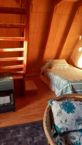 Cette chambre mansardée comprend deux lits et le chauffage. dans l'établissement Cabañas Linda Vista, à Cucao