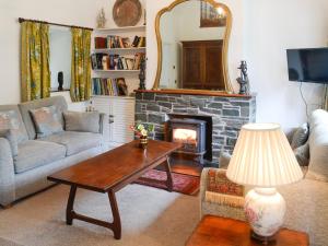 Holly Cottage - 28140 في Boreland of Colvend: غرفة معيشة مع أريكة ومدفأة
