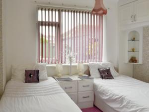 سرير أو أسرّة في غرفة في Rossall Beach Cottage