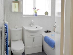 a bathroom with a toilet and a sink and a tub at Rossall Beach Cottage in Cleveleys