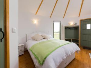 a bedroom with a large bed with a green door at Olive in Wootton Bridge