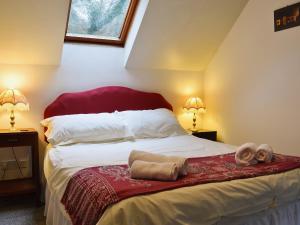 a bedroom with a bed with two towels on it at Erw Goed Hen Feudy in Arthog