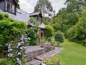 a house with a stone path leading to a garden at Erw Goed Hen Feudy in Arthog