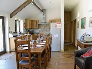 a kitchen and dining room with a table and a refrigerator at The Old Forge in West Lutton