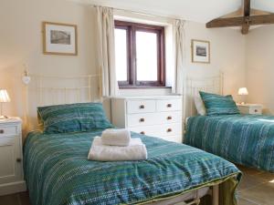 a bedroom with two twin beds and a window at The Old Forge in West Lutton