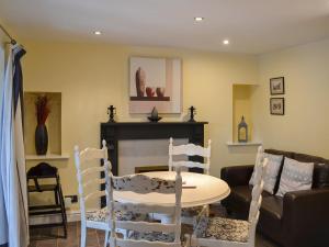 a living room with a table and chairs and a couch at Brewers Cottage in Cropton