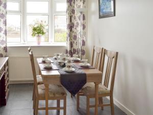 a dining room table with cups and saucers on it at Rossall Beach Cottage in Cleveleys